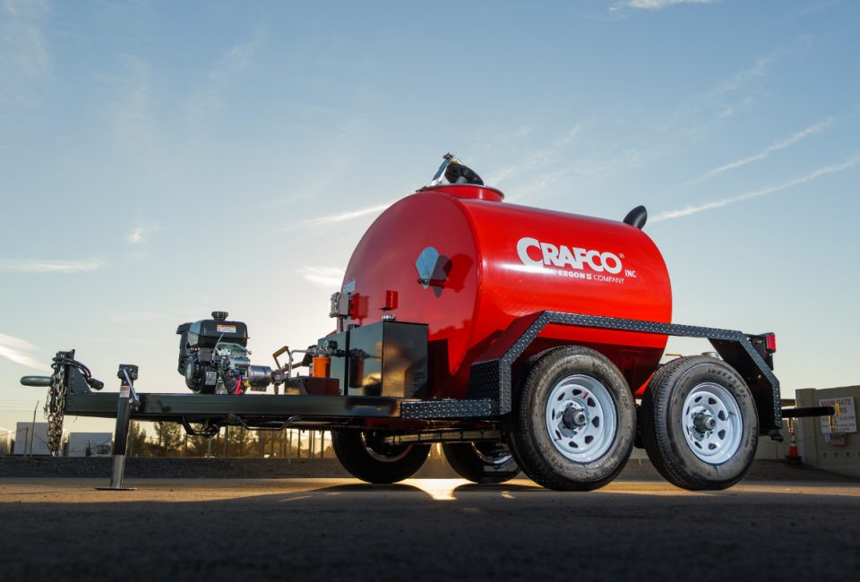 A trailer-mounted tank painted red against a subtle sunrise.